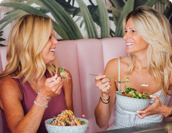 Two women enjoying healthy salads